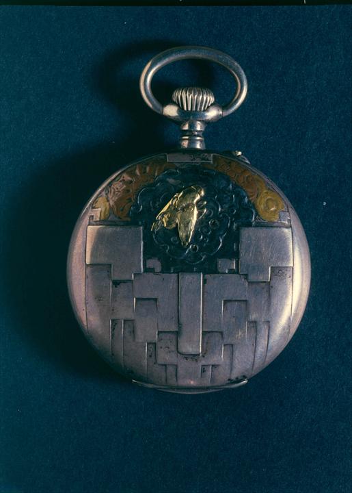 Часы, отчеканенные Шарлем-Эдуардом Жаннере в пятнадцатилетием возрасте, с применением серебра, стали, меди, золота и других металлов, получают почетный диплом на Международной выставке декоративного искусства в Турине в 1902 году.